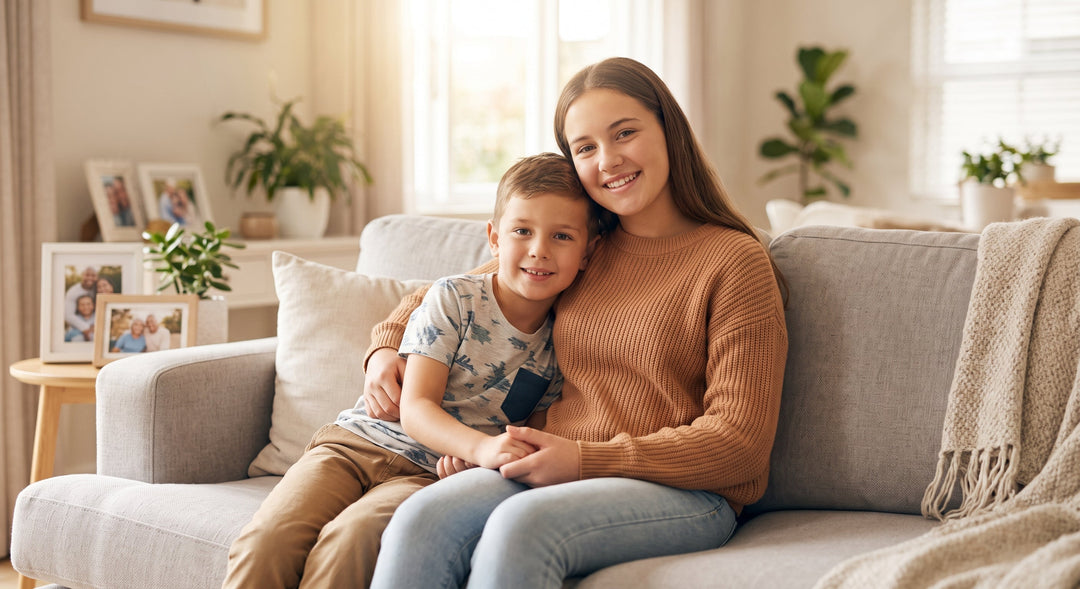 A teenage girl and younger boy sitting on a couch in a warm home setting, representing children's input in custody decisions.